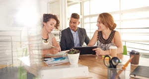group of three people meeting at a table