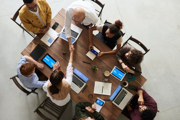 An overhead shot of a group of people collaborating around a table.