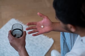 View of a young man about to take a pill